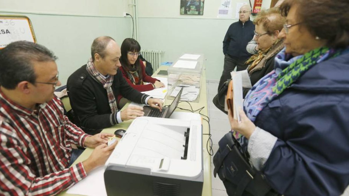 Miembros de una mesa electoral comprueban los datos de identificación de una votante.-RAÚL G. OCHOA