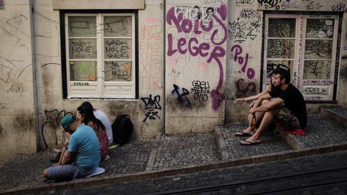 Unos turistas esperan la llegada del tranvía en Lisboa.-CARLOS MONTAÑÉS.