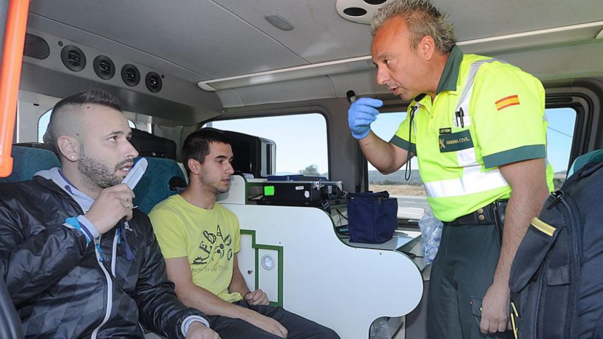 Un agente de la guardia civil explica a un joven cómo se realiza la prueba en un control al que asistieron los medios de comunicación.-ISRAEL L. MURILLO