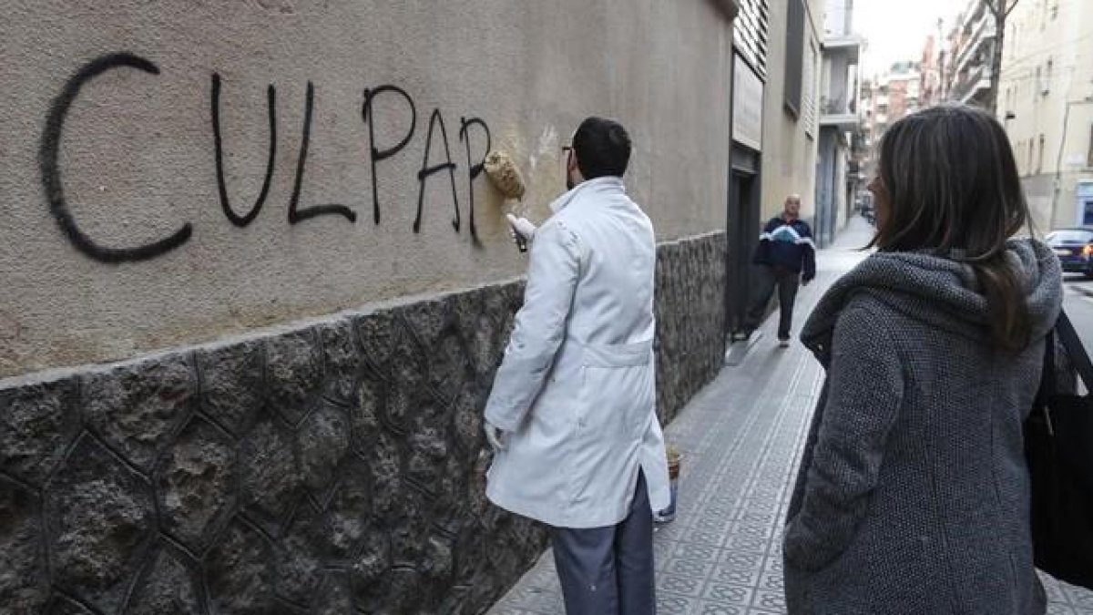 Un trabajador borra una pintada en el muro del colegio de los Maristas de Sants-Les Corts, tras estallar el escándalo de pederastia en el centro.-JULIO CARBÓ