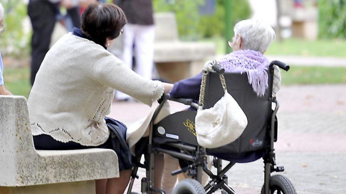 Una mujer cuida de una anciana.-RAÚL G. OCHOA