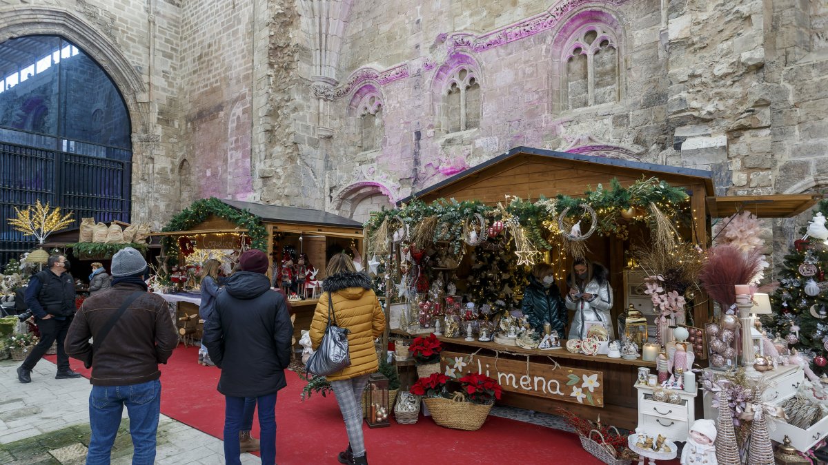 Varias personas observan los puestos de flores en la Feria Florista de Navidad, en el Monasterio de San Juan. SANTI OTERO