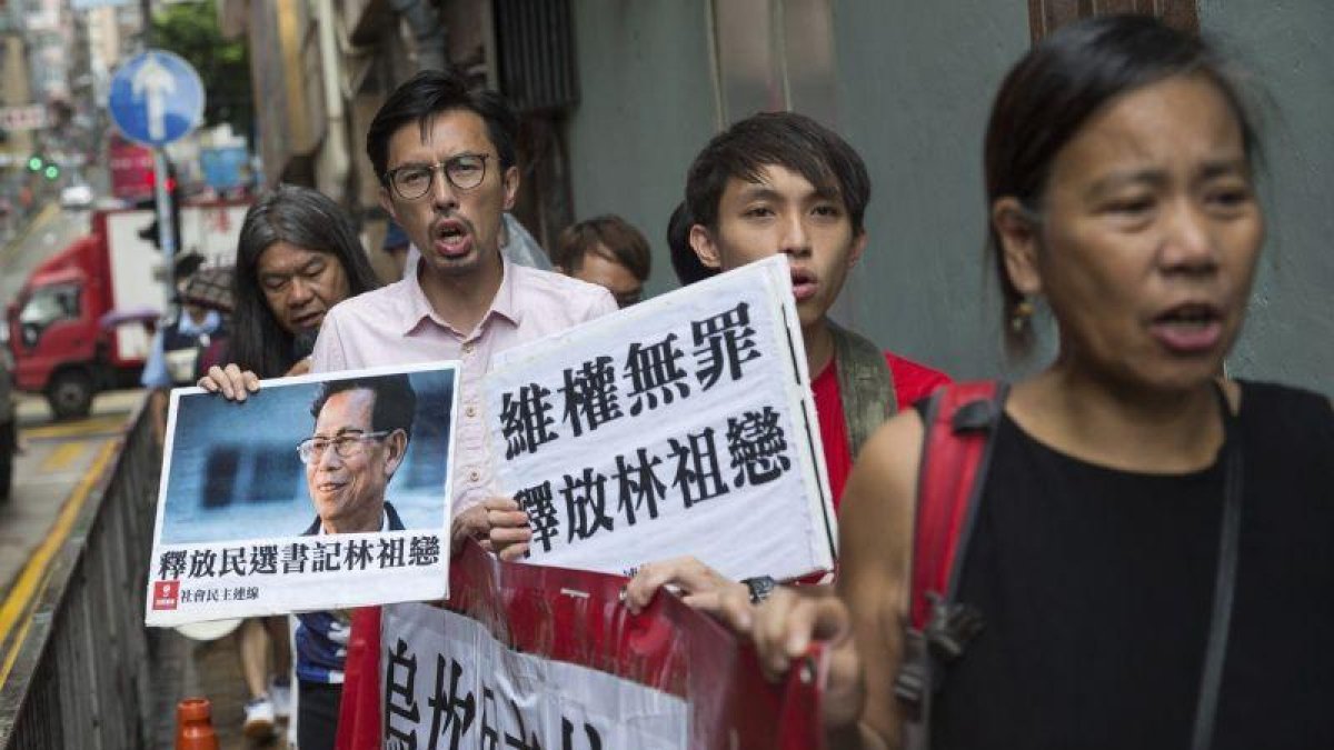 Varios seguidores del alcalde de la localidad meriodional de Wukan, Lin Zuluan, sostienen pancartas y protestan de camino a la oficina china Liaison en Hong Kong.-JEROME FAVRE / EFE