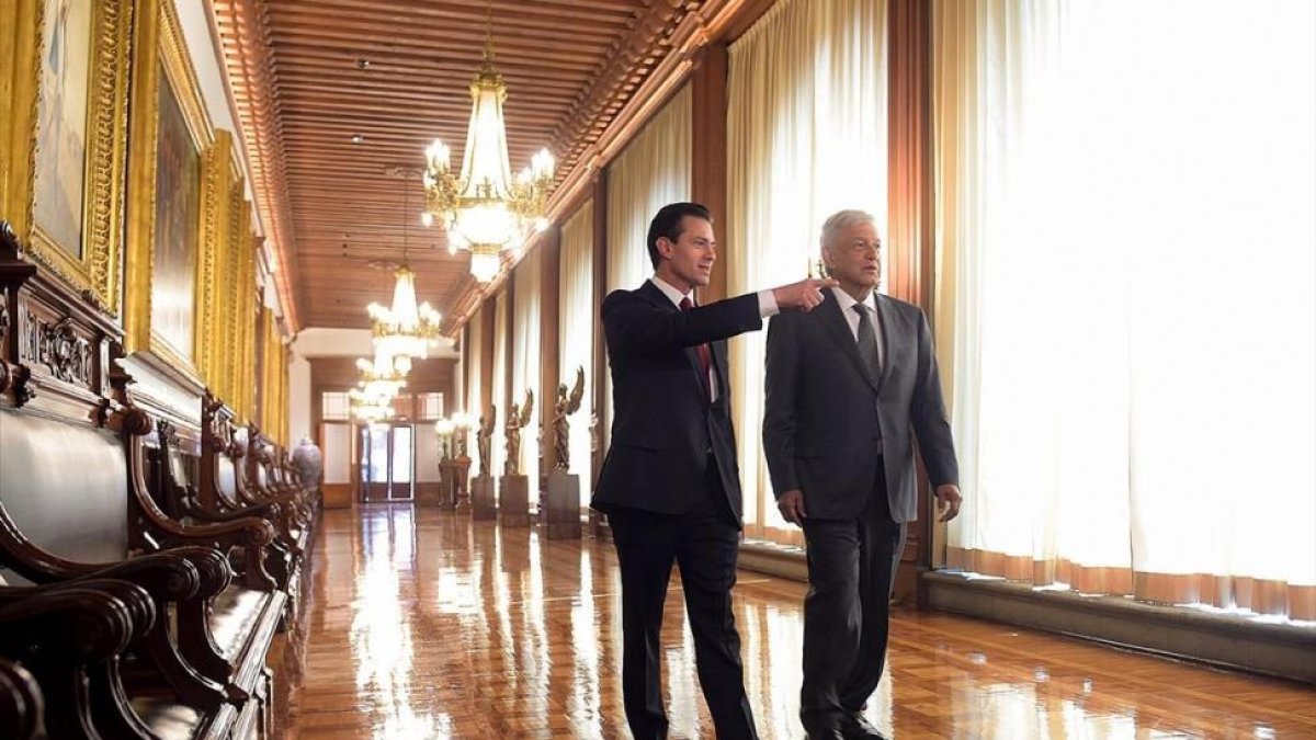 Peña Nieto acompaña a López Obrador por el palacio presidencial. /-AP