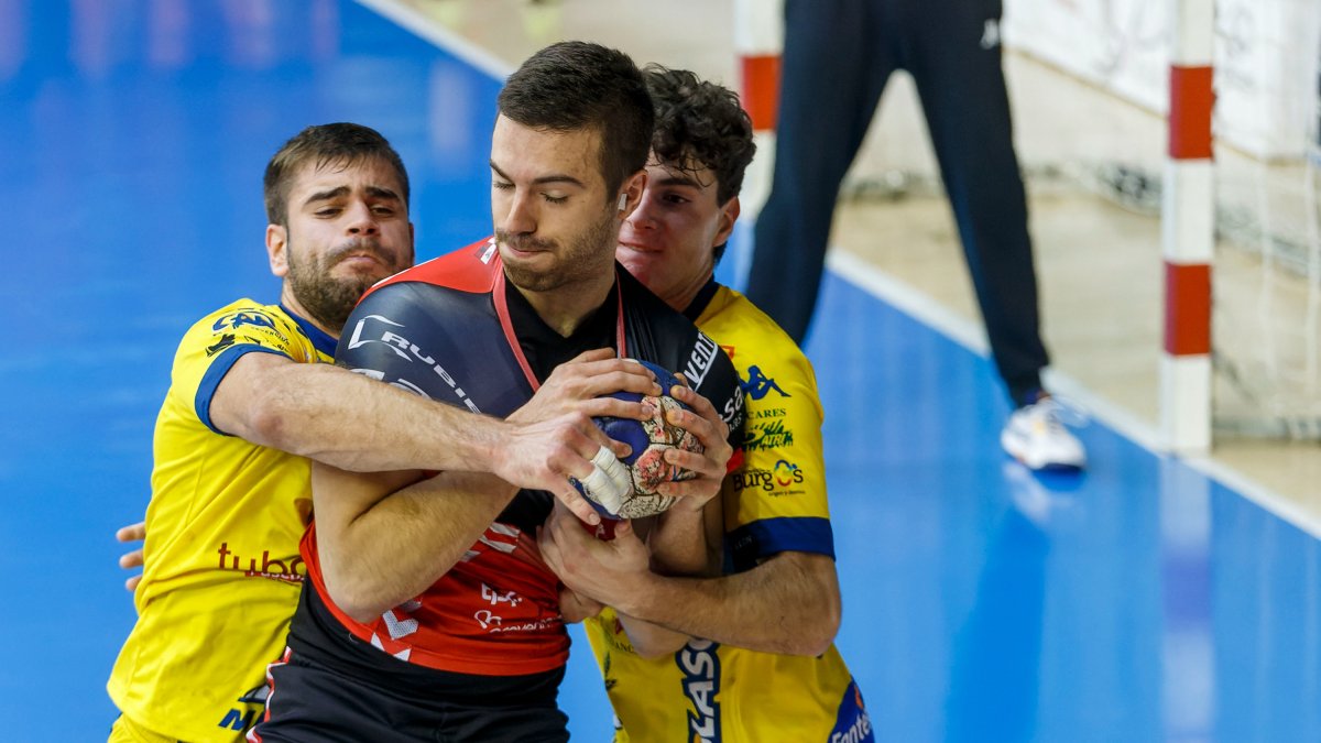 Lander Simón defendido por dos jugadores del Villa de Aranda. TOMÁS ALONSO