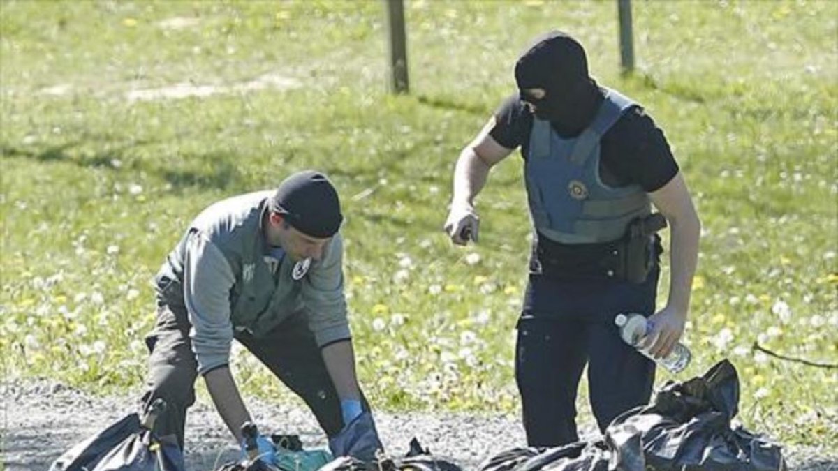 Policías franceses examinan las armas de uno de los zulos de ETA.-GUILLAUME HORCAJUELO