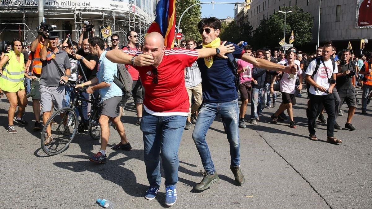 Un asistente a la manifestación de la Policía es agredido por un independentista, este sábado en Barcelona.-ELISENDA PONS