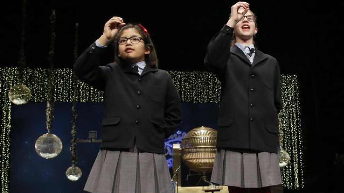 Las niñas de San Ildefonso Lorena Stefan y Nicol Valenzuela muestran las bolas del número 79140, el Gordo de Navidad.-EFE / SERGIO BARRENECHEA