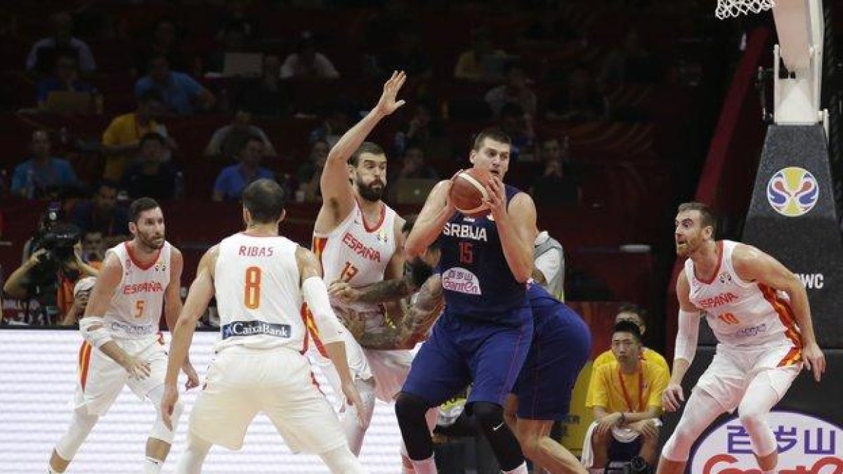 La estrella serbia Nikola Jokic (c) intenta manejar el balón ante la oposición de la defensa española.-X01757