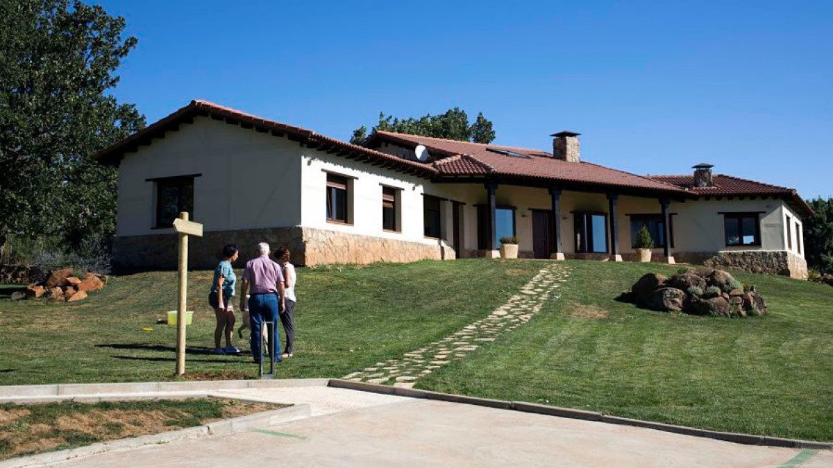 Un grupo de personas charla en el exterior de una casa rural. ICAL