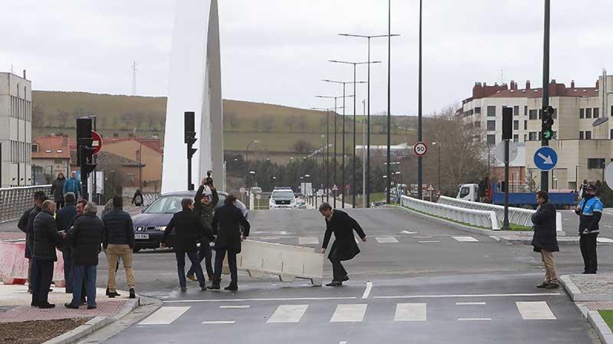 Lacalle ayuda a retirar las barreras que cerraban el paso del nuevo vial que une el puente con Valentín Niño.-RAÚL OCHOA