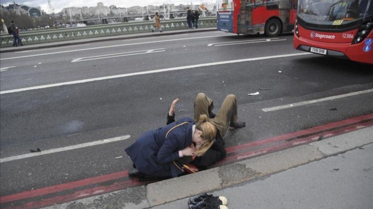 Una mujer atiende a un herido en el puente de Londres.-REUTERS / TOBY MELVILLE
