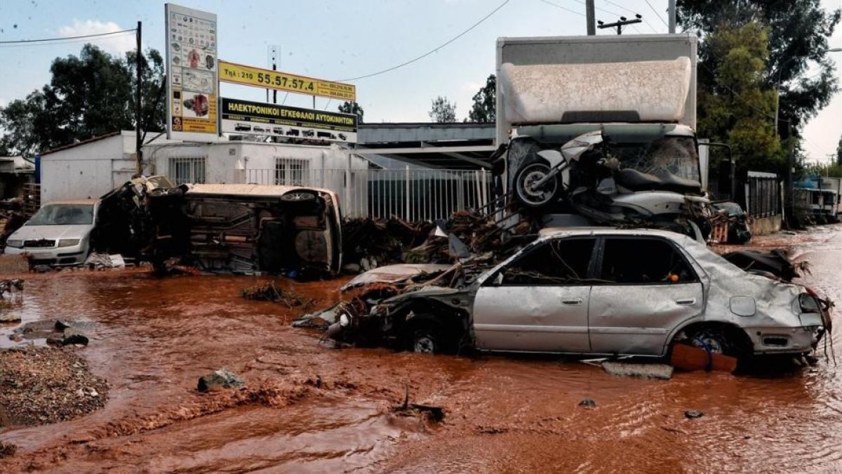 Vehículos en medio del fango en calles inundadas en Mandra (Grecia), tras las lluvias torrenciales, el 15 de noviembre.-EFE / YANNIS KEMMOS