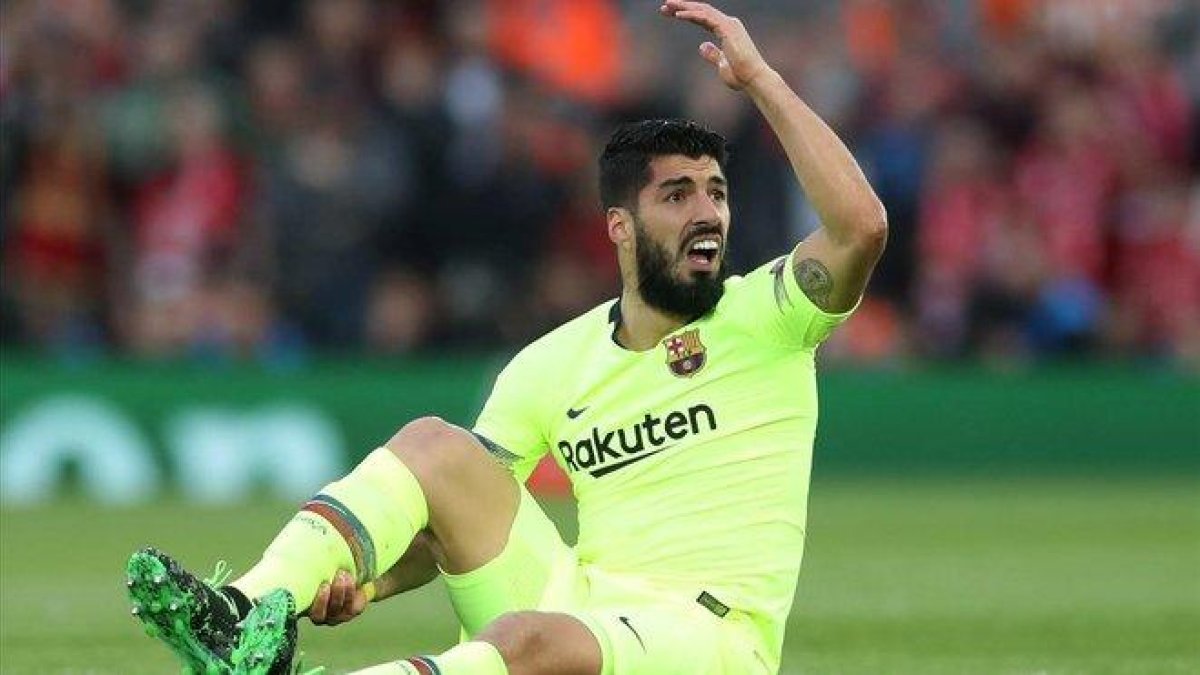 Suárez se lamenta en Anfield donde sufrió una rotura de menisco.-REUTERS / CARL RECINE