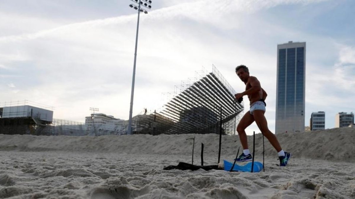 Un corredor pasa cerca del cuerpo mutilado encontrado de la zona del volei playa que está en Copacabana-SERGIO MORAES / REUTERS