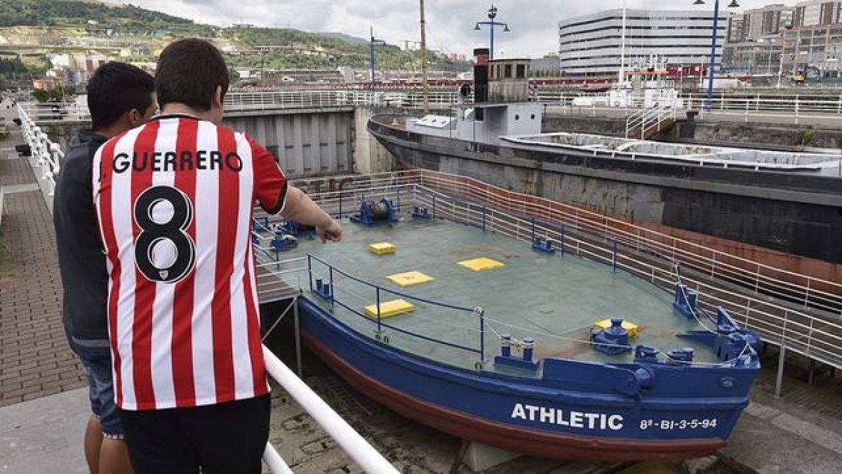 Dos jóvenes observan la gabarra con la que el Athletic Club celebró sus títulos en 1983 y 1984, que no saldrá del Museo Marítimo de Bilbao para festejar la Supercopa de España.-Foto: EFE / MIGUEL TOÑA
