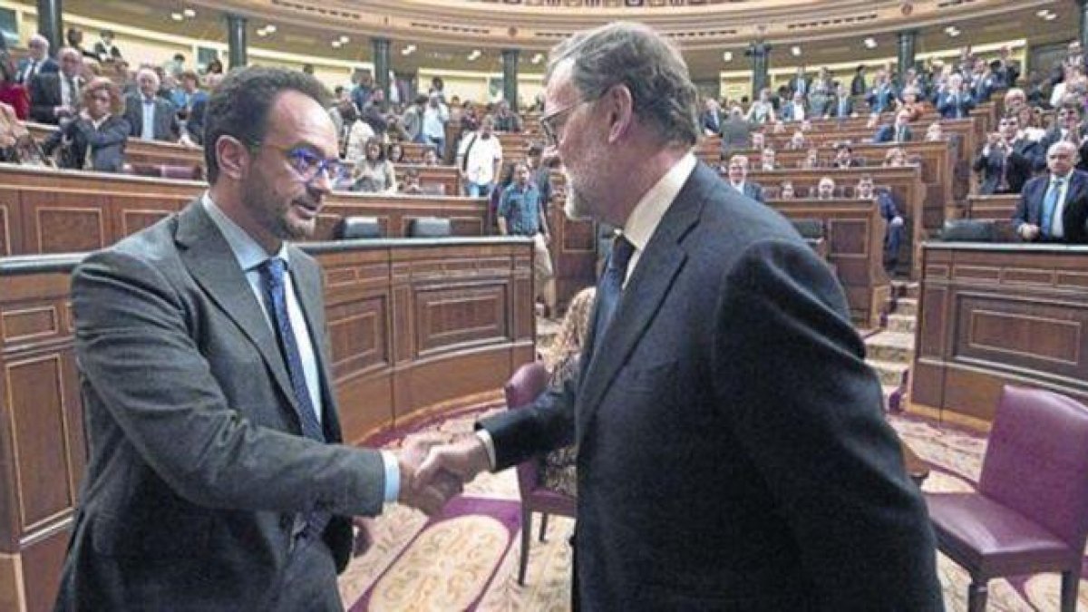 Mariano Rajoy y el socialista Antonio Hernando se dan la mano tras la segunda votación del pleno de investidura.-POOL