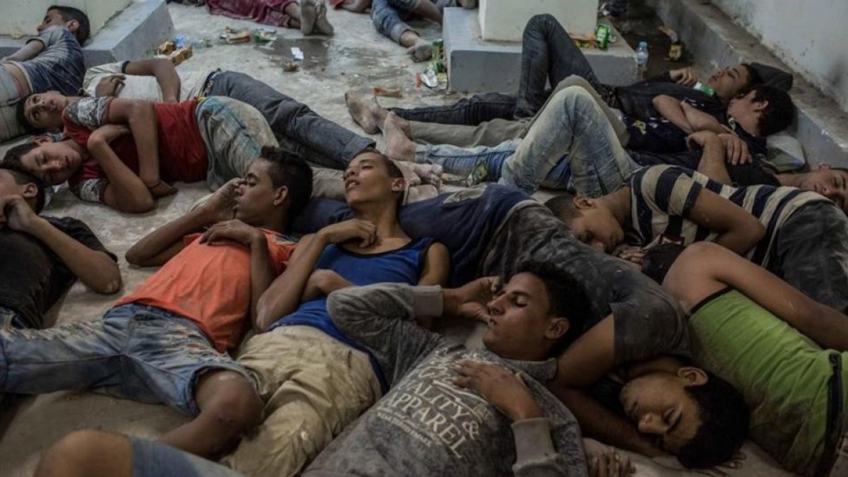 Supervivientes del naufragio duermen en una comisaría tras ser rescatados.-AP / EMAN HELAL