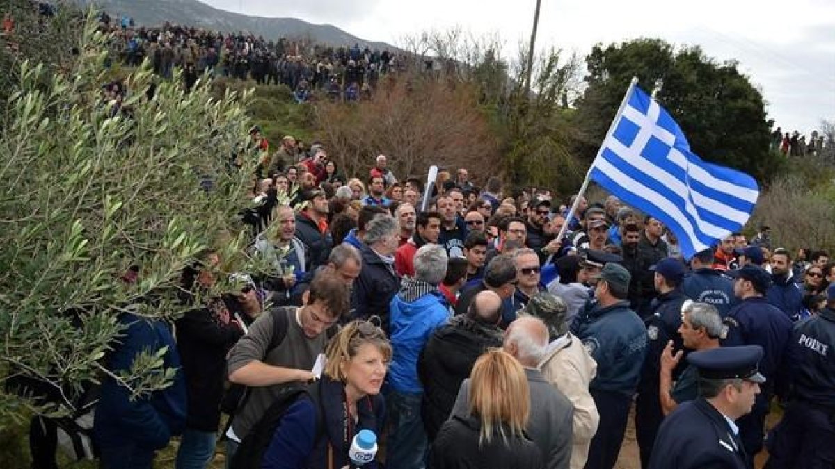 Manifestantes con carteles y banderas griegas durante una marcha contra la construcción de un 'hotspot' en Kos, el 14 de febrero.-EFE / YANNIS KIARIS