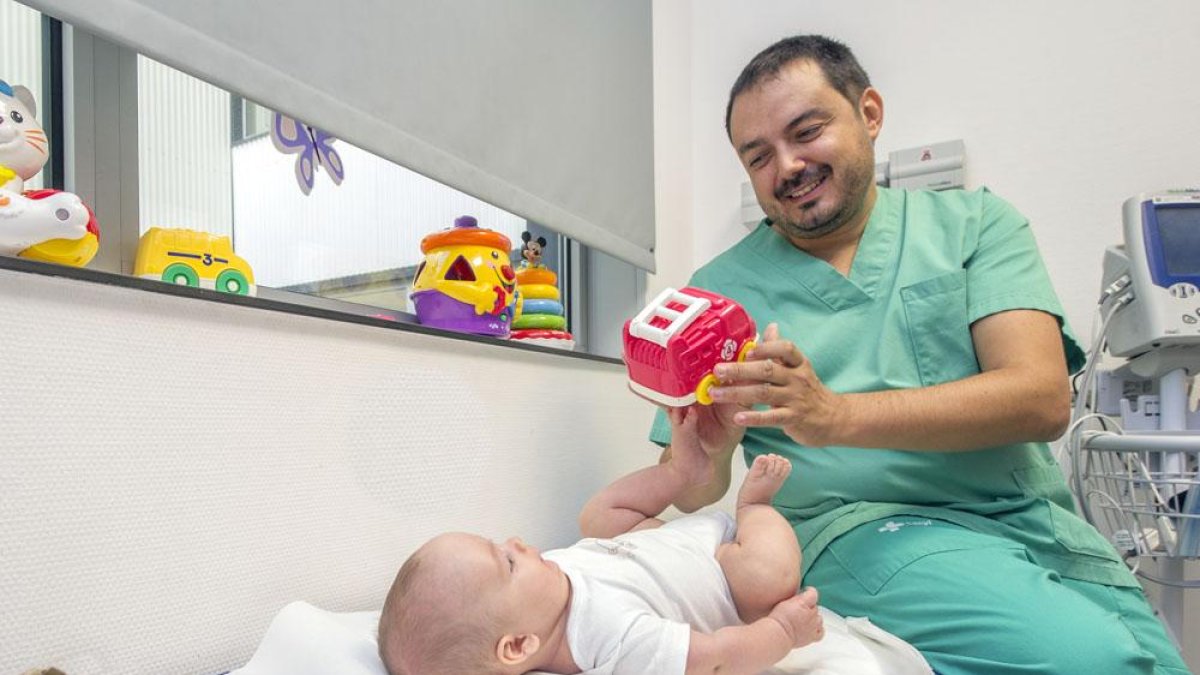 El doctor realiza una exploración a un bebé en su consulta del Hospital Universitario de Burgos.-ISRAEL L. MURILLO