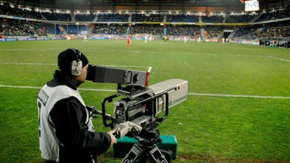 Un cámara de una cadena de televisión toma imágenes durante un partido de fútbol.-ARCHIVO