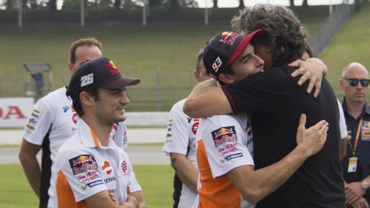 Paolo Simoncelli recibe el abrazo de Marc Márquez, ante la presencia de Dani Pedrosa, en el reciente homenaje que MotoGP dedicó, en Sepang (Malasia), a su hijo Marco.-GETTY / MIRCO LAZZARI