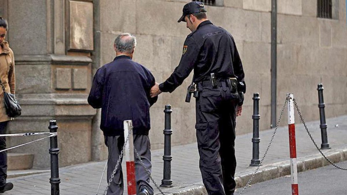 Un agente ayuda a una persona mayor.-ECB