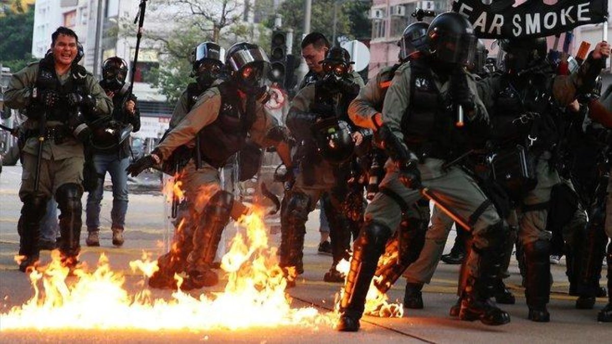 Agentes de policía en Hong Kong se preparan para una actuación entre llamas.-EFE / JEROME FAVRE