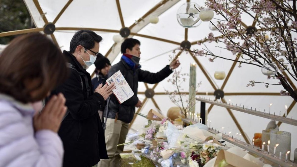 Varias personas rezan durante un evento celebrado en memoria de las víctimas del terremoto y posterior tsunami, el 11 de marzo del 2016.-FRANK ROBICHON (EFE)