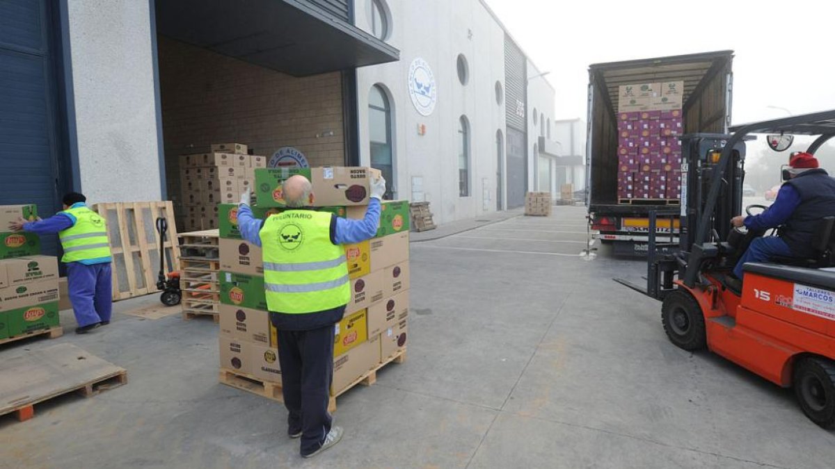 Varios voluntarios descargan cajas de productos.-ISRAEL L. MURILLO