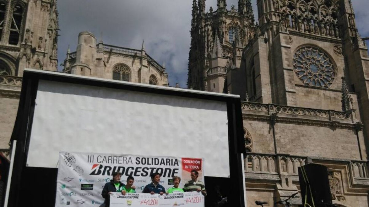 Representantes de Síndrome de Down y Alzheimer Burgos reciben los cheques con la cantidad reunida en la III Carrera Popular Solidaria Bridgestone.-ECB