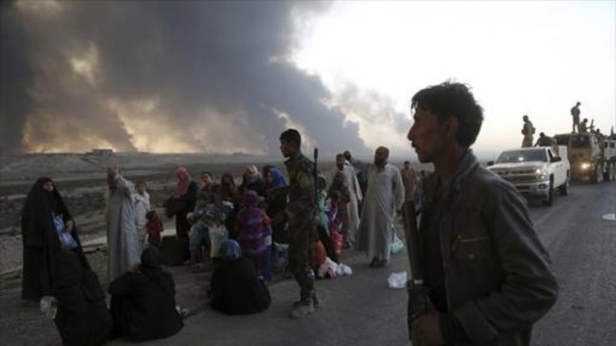 Familias iraquís, desplazadas de Mosul, cerca aún de los combates, ayer.-AP