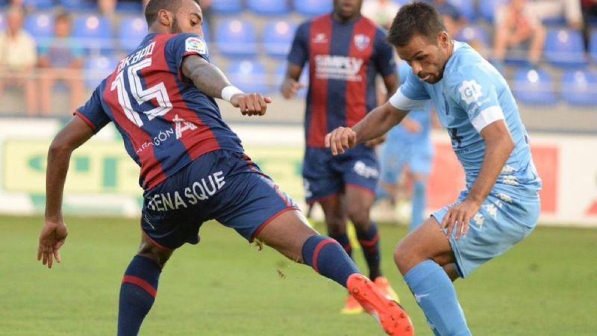 El jugador del Girona, Felipe Sanchón, trata de marcharse del defensa del Huesca, Carlos Akapo.-@GironaFC