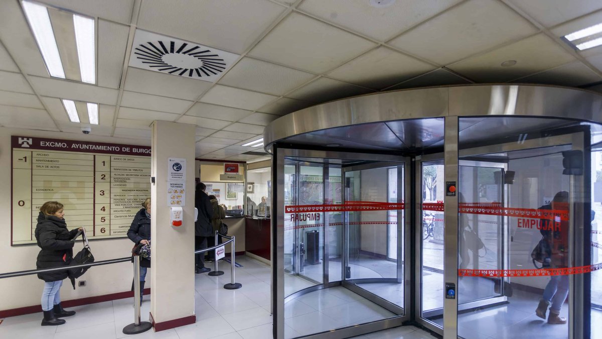 La puerta giratoria del Ayuntamiento y varios ciudadanos haciendo cola en el registro municipal. SANTI OTERO