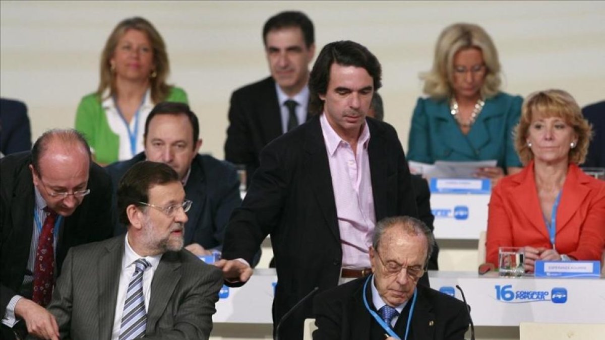 José María Aznar pasa por el lado de Mariano Rajoy, sentado junto a Manuel Fraga, en la clausura del XVI congreso nacional del PP, en el 2008 en Valencia-MIGUEL LORENZO