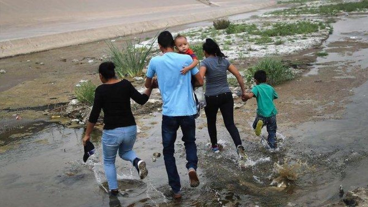 Una familia de inmigrantes cruzan de manera ilegal la frontera entre México y los EEUU. / MARIO TAMA (AFP)-AFP / MARIO TAMA