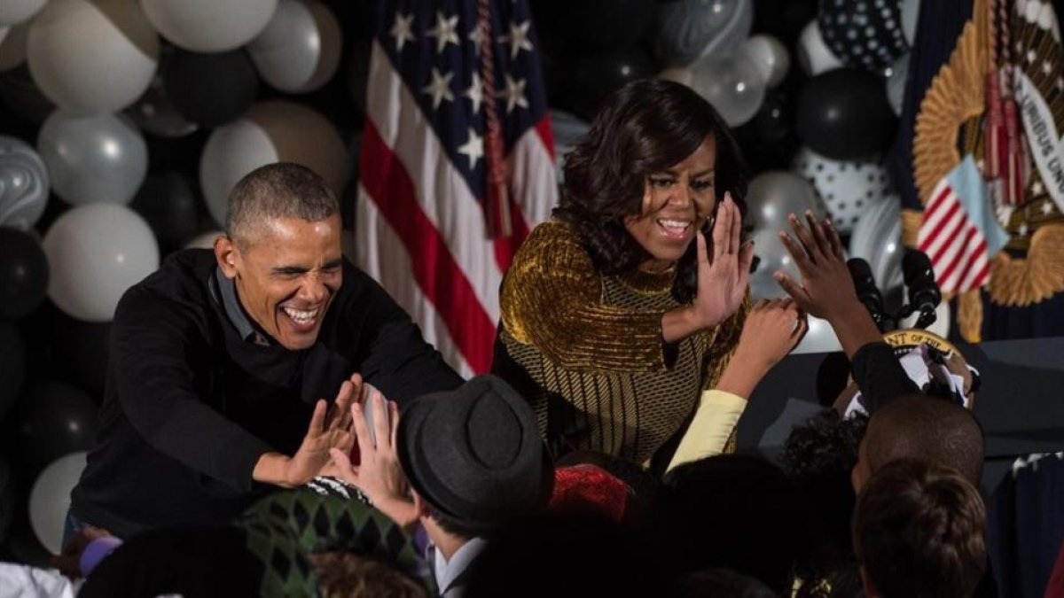 Obama y su mujer, Michelle, saludan a un grupo de niños en un evento por Halloween en la Casa Blanca, en Washington.-AFP / NICHOLAS KAMM