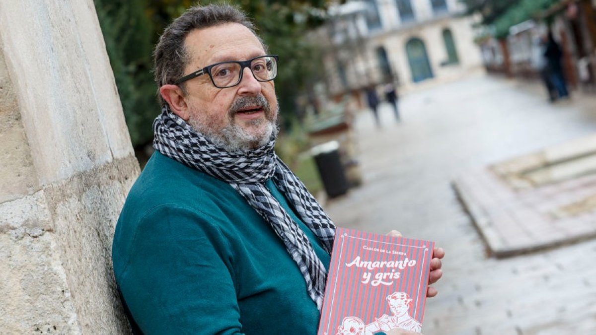 El escritor burgalés Carlos de la Sierra con un ejemplar de su último libro, 'Amaranto y gris', en el paseo del Espolón. SANTI OTERO