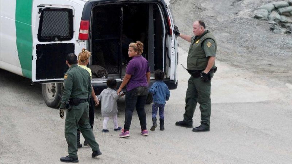 Oficiales de fronteras detienen a una mujer y su hijo integrantes de la caravana de inmigrantes de Centro América.-REUTERS MOHAMMED SALEM