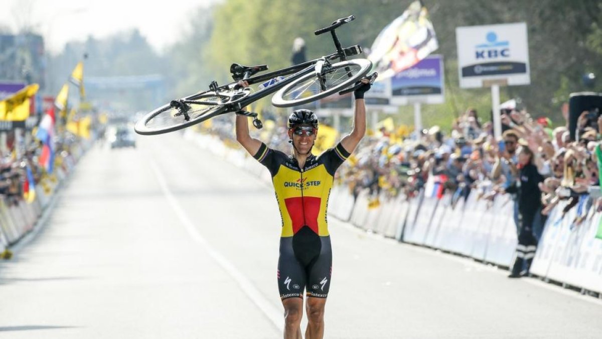 Philippe Gilbert cruza la meta de Flandes con la bici a cuestas.-JULIEN WARNAND