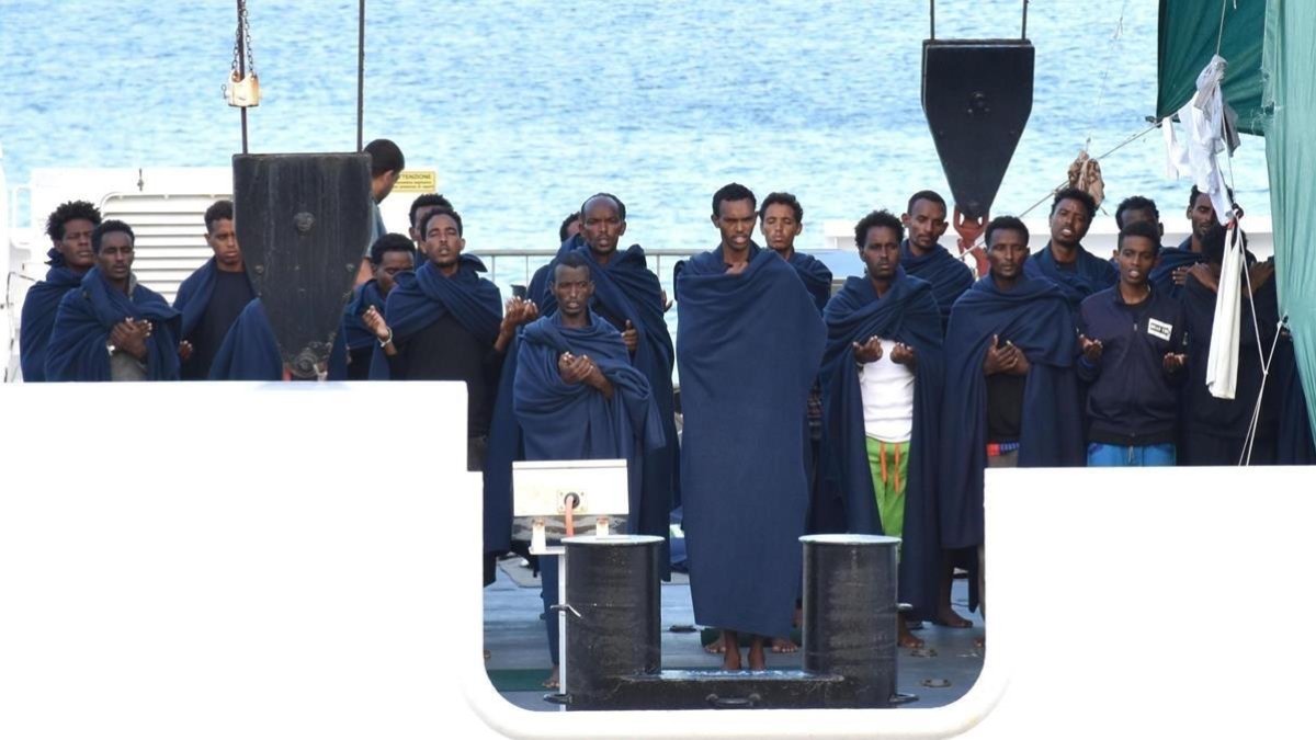 Un grupo de personas reza a bordo del Diociotti, atracado desde hace unos días en el puerto de Catania (Sicilia).-ORIETTA SCARDINO