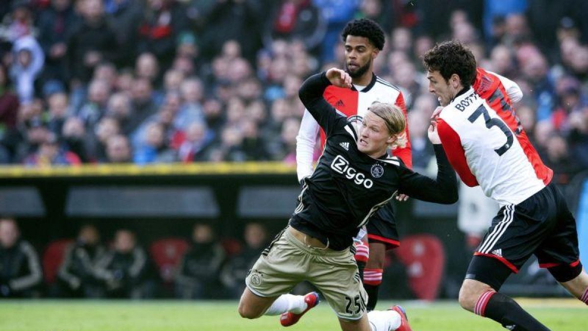 El delantero del Ajax Dolberg cae en la lucha de un balón en el partido ante el Feyenoord.-ANP