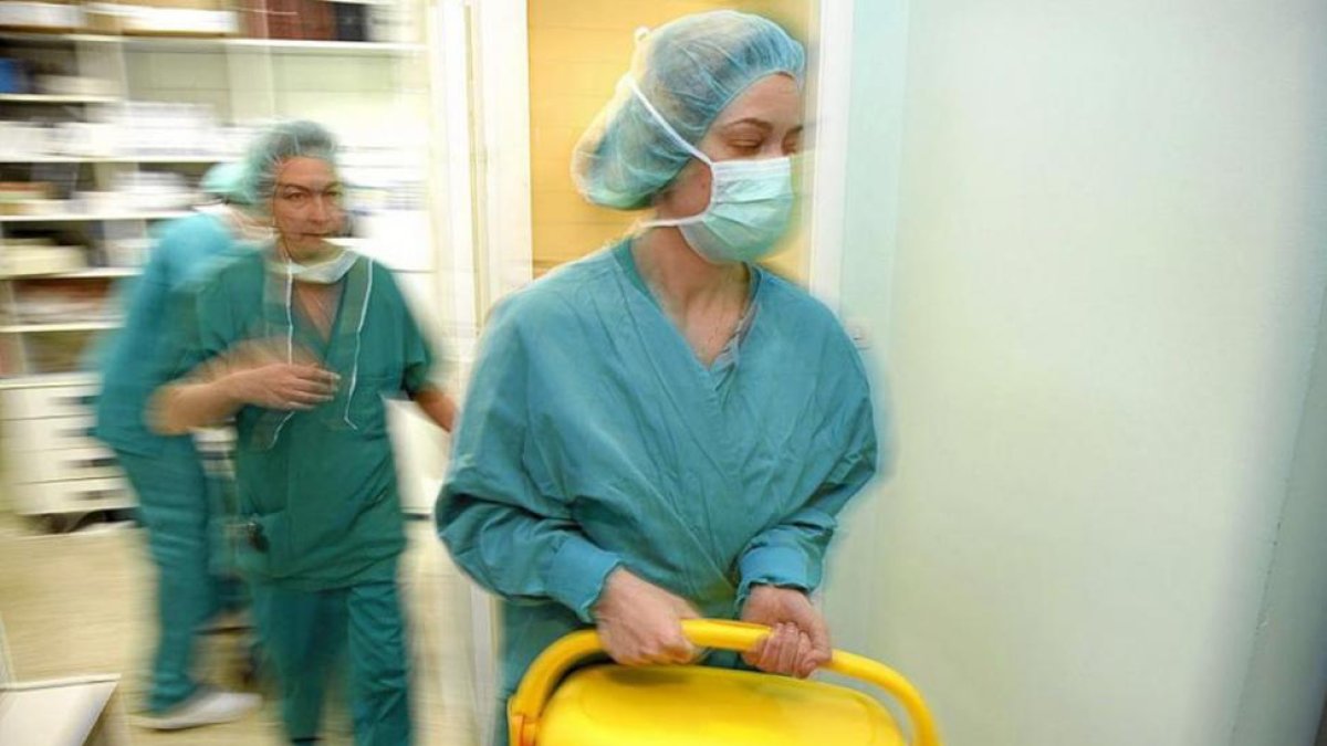 Dos profesionales sanitarias trasladan una nevera con un órgano para trasplantar.-ECB