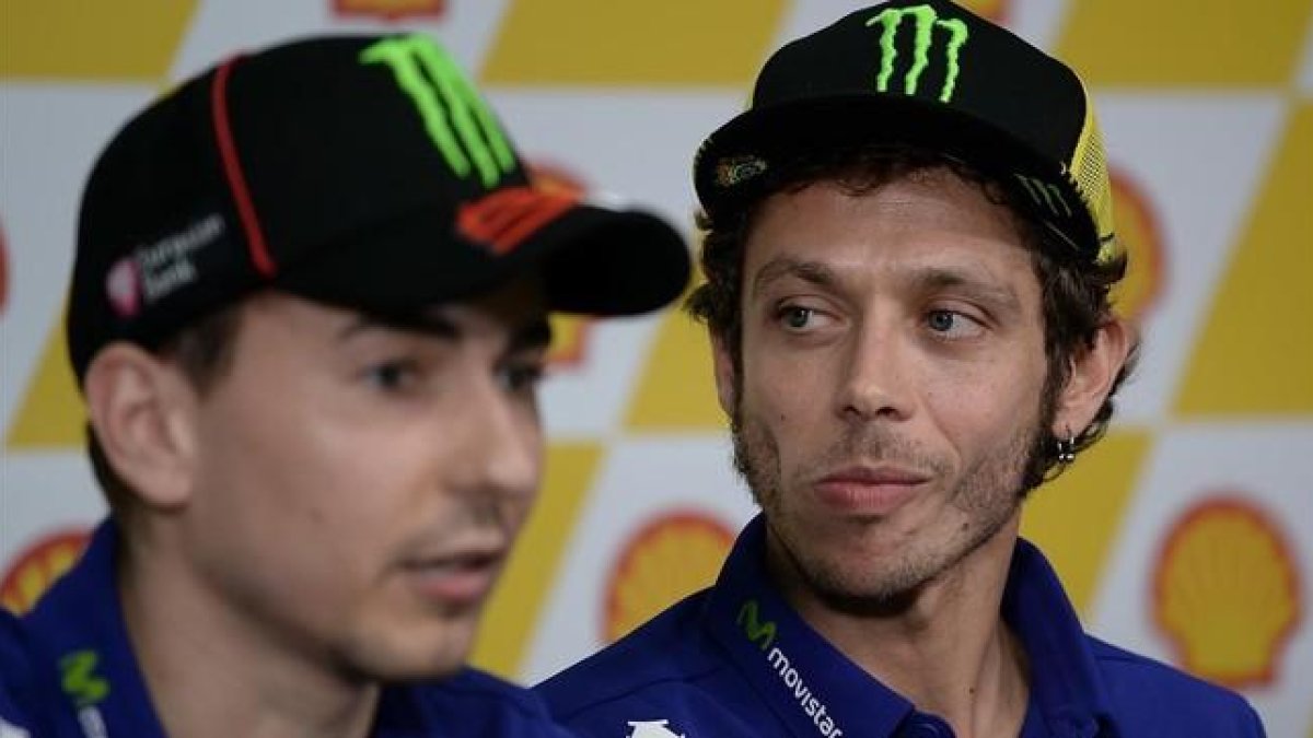 El piloto italiano Valentino Rossi escuchando las declaraciones de su compañero de equipo Jorge Lorenzo.-AFP / MANAN VATSYAYANA