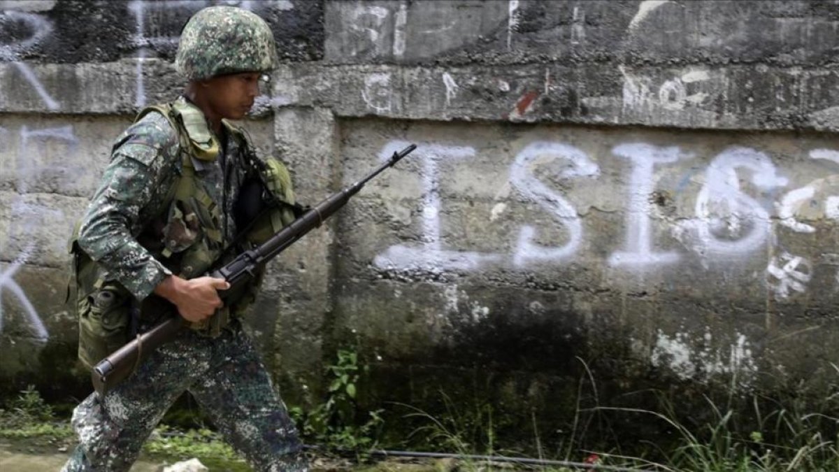 Un soldado filipino patrulla por un vecindario despues de un bombardeo durante los combates contra el EI.-FRANCIS R MALASIG