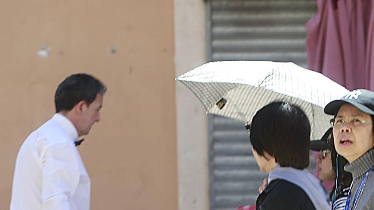 Un camarero prepara una mesa en la terraza de un local de hostelería.-RAÚL G. OCHOA