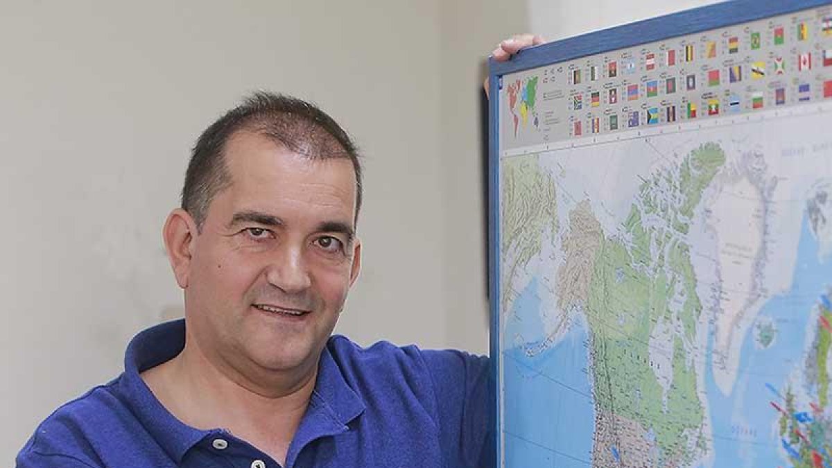 Delgado posa en la sede de la delegación de misiones con un mapa en el que una serie de banderitas indican la presencia de algún misionero burgalés en ese punto del globo.-RAÚL OCHOA