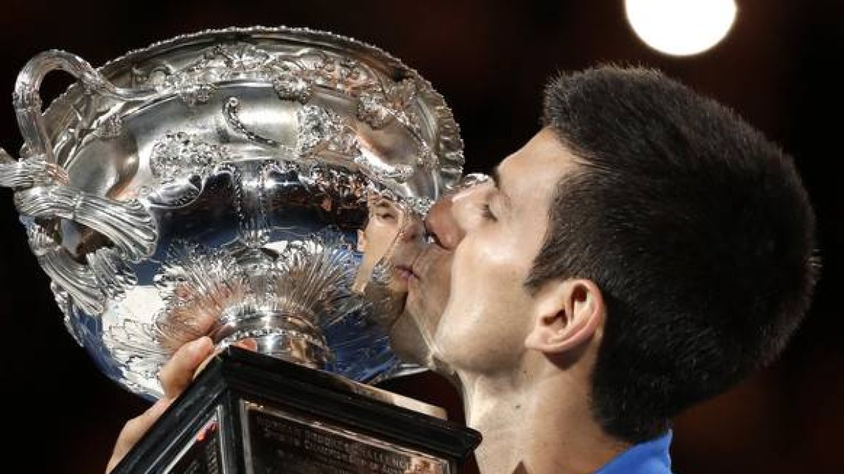 Novak Djokovic besa el trofeo que le acredita como campón del Abierto de Australia.-AP