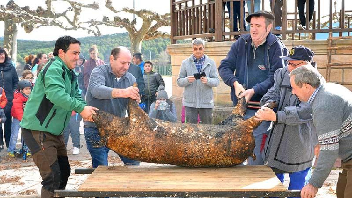 Vecinos con experiencia en la matanza cogen al gorrino bajo la atenta mirada de adultos y pequeños.-R.F.