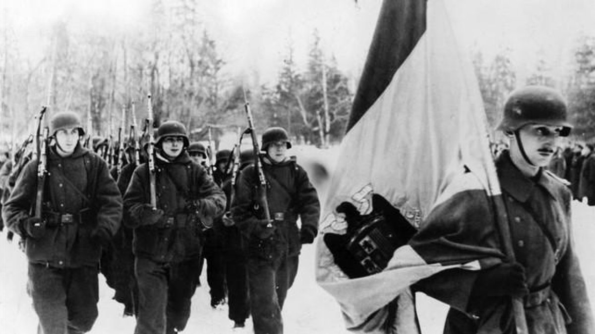 Integrantes de la División Azul, con el uniforme alemán de la 250 División de Infantería, desfila tras la bandera de la España de Franco camino de Leningrado.-ARCHIVO
